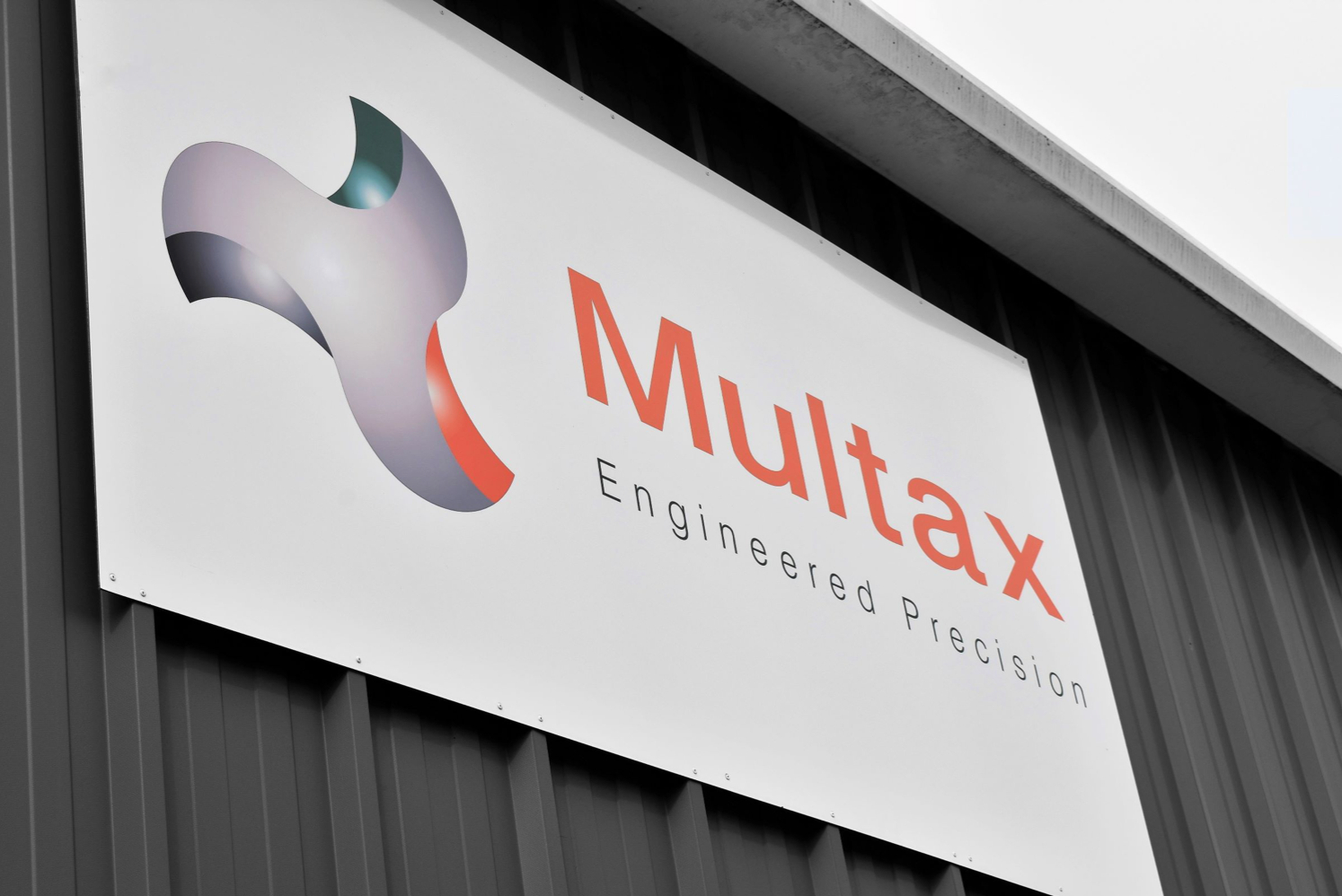 A sign on a building saying Multax Engineered Precision.